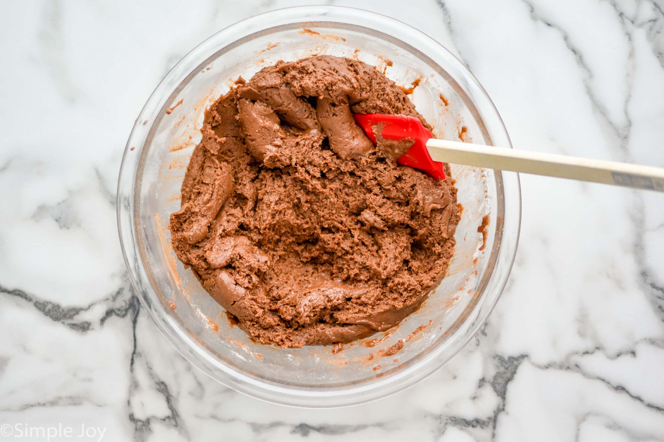 overhead bowl of caramel brownies ingredients with spatula for mixing