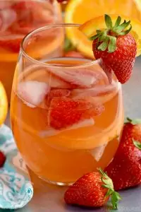 a close up glass of sangria with strawberries and oranges in it