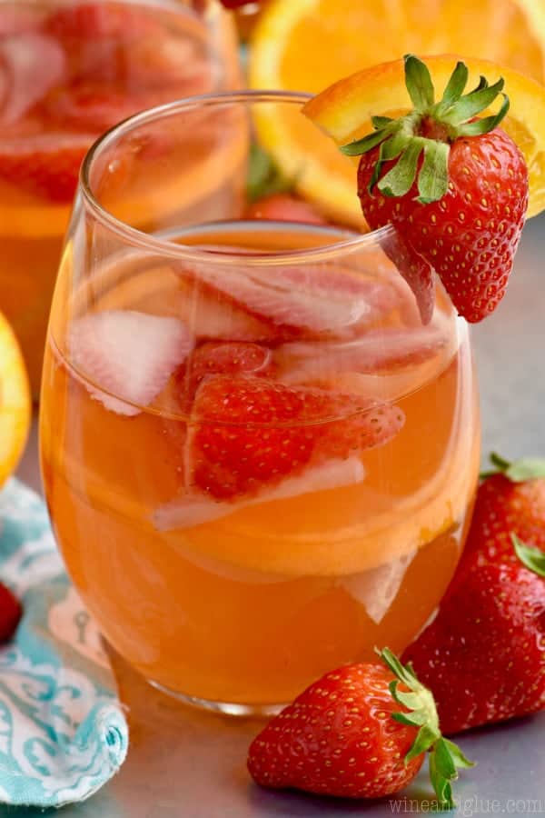 a close up glass of sangria with strawberries and oranges in it