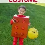 little girl wearing an easy halloween costume shaped as a lego