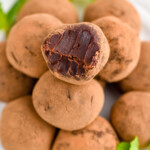 overhead of a plate of chocolate truffles with a bite missing out of the top one - 15
