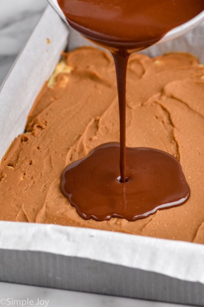 Photo of chocolate layer being poured onto pan of Cookie Butter Bars recipe.