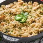 side view of a frying pan full of Thai Basil fried rice recipe garnished with Thai Basil and sliced jalapeños - 6