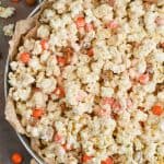 a large metal tray with parchment paper full of pumpkin spice white chocolate popcorn - 11