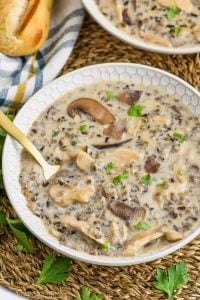 overhead view of creamy chicken and wild rice soup recipe in a bowl, garnished with parsley