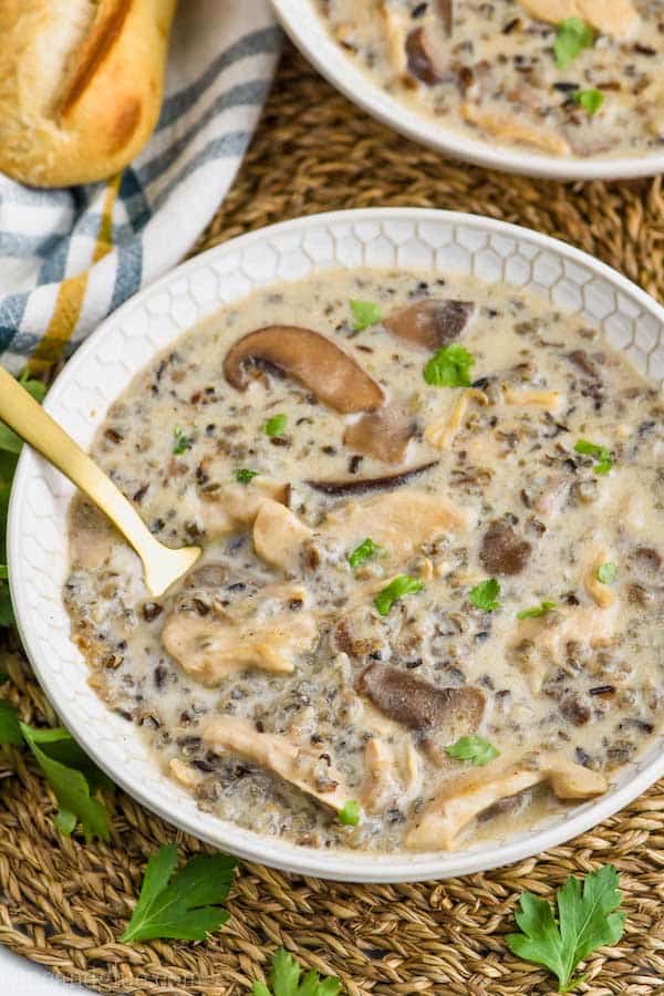 overhead view of creamy chicken and wild rice soup recipe in a bowl, garnished with parsley