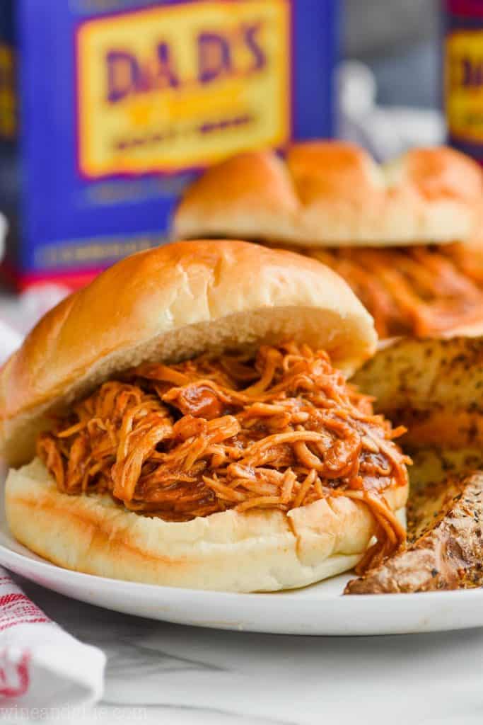 root beer slow cooker bbq chicken sandwich close up on a plate with brioche buns