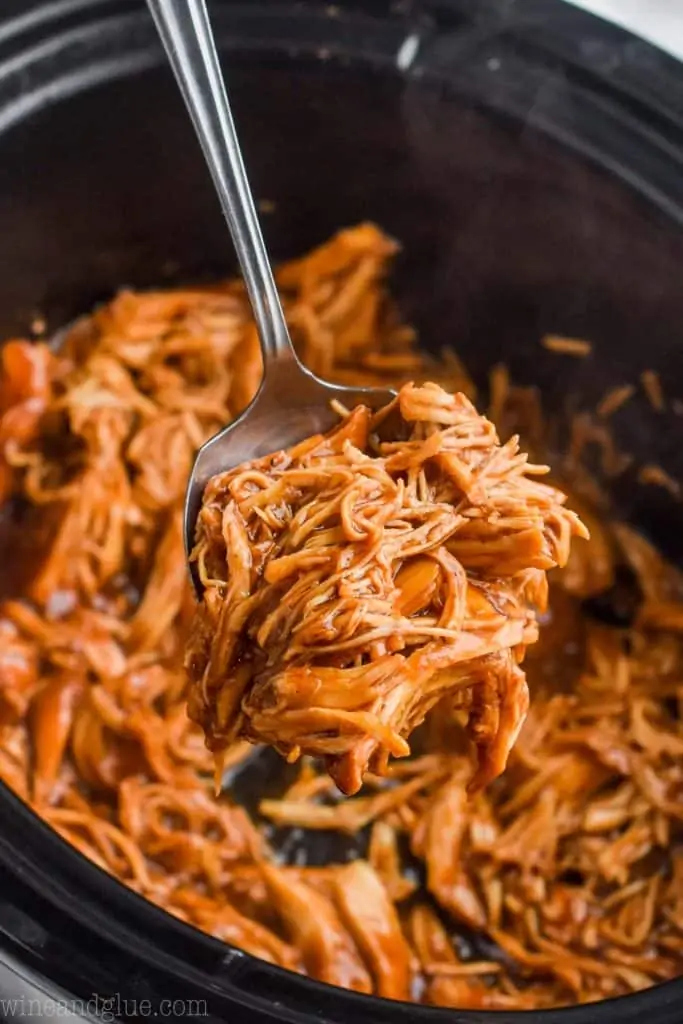 bbq chicken being dished out of a slow cooker