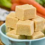 three layers of pieces of carrot cake fudge in a teal dish - 11