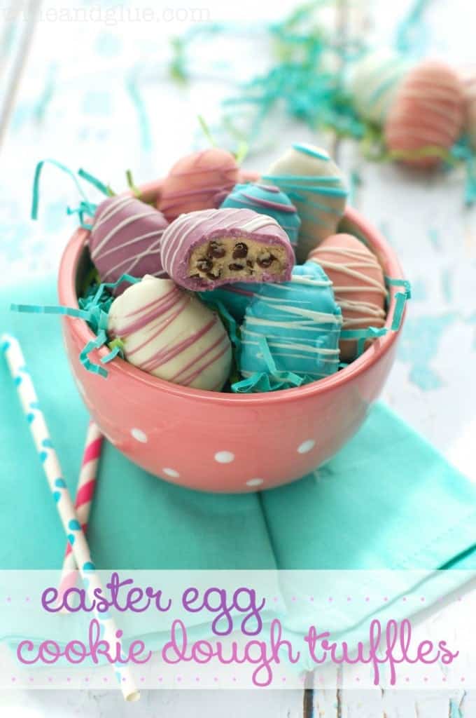 In a pink bowl, the Easter Egg Cookie Dough Truffles is covered with different colored chocolates (white, pink, purple, and blue) and drizzled with different colored stripes. 