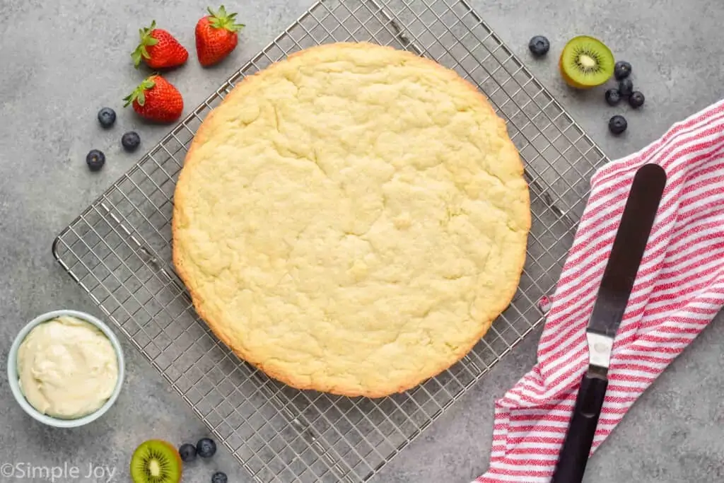 overhead view of a giant pizza sized sugar cookie on a cooling rack