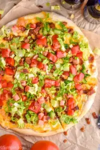 overhead of a blt pizza with one piece cut into