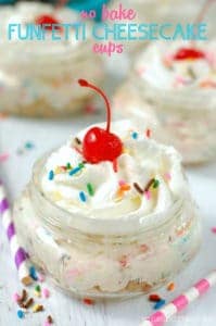 close up of a mason jar with no bake cheesecake, topped with a cherry, whipped cream and sprinkles, says no bake funfetti cheesecake cups - 8