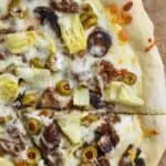 overhead view of half of a white pizza recipe with one piece cut out and still sitting there