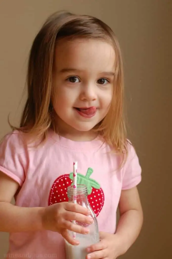 picture of a little girl holding a bottle of milk