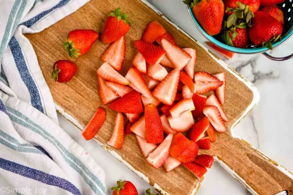 overhead of strawberries cut up on a cutting board