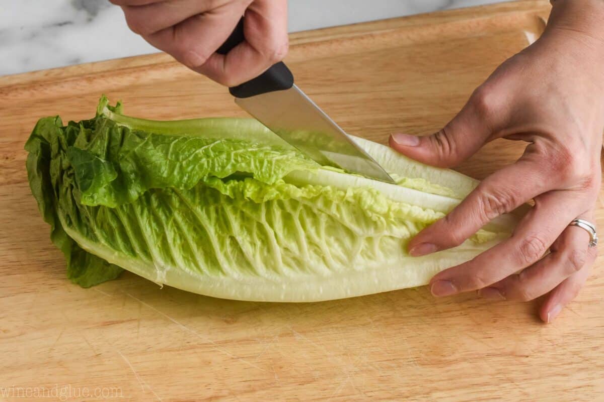 cutting a romaine lettuce. heart length wise for a salad