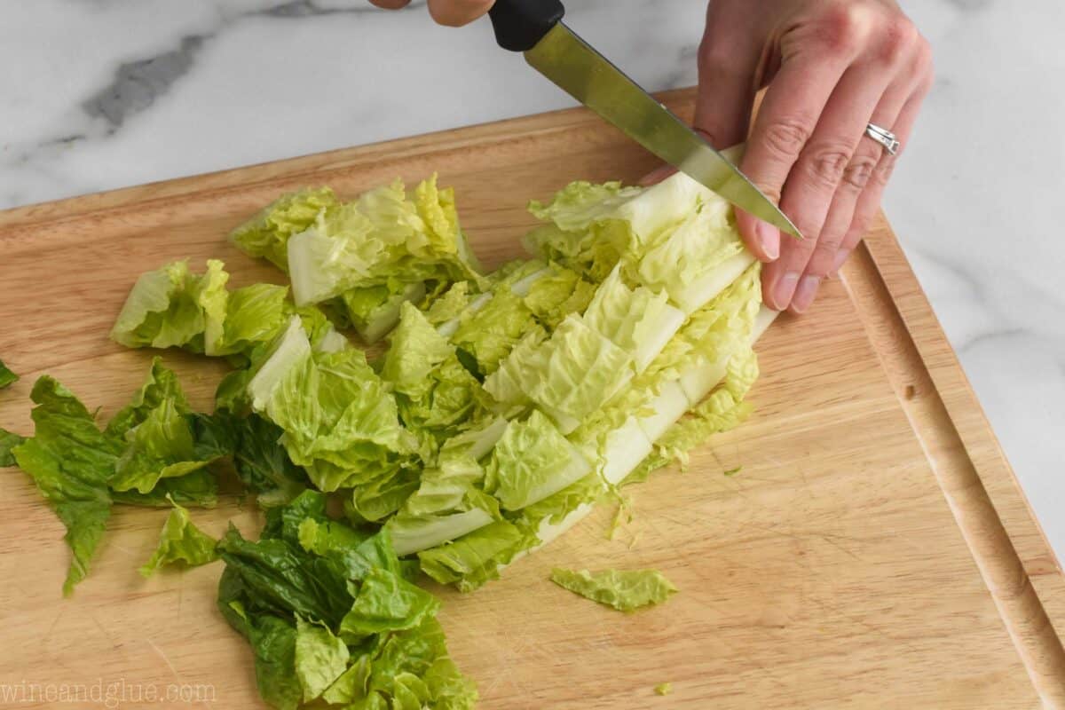 slicing a romaine heart width wise into strips for a salad
