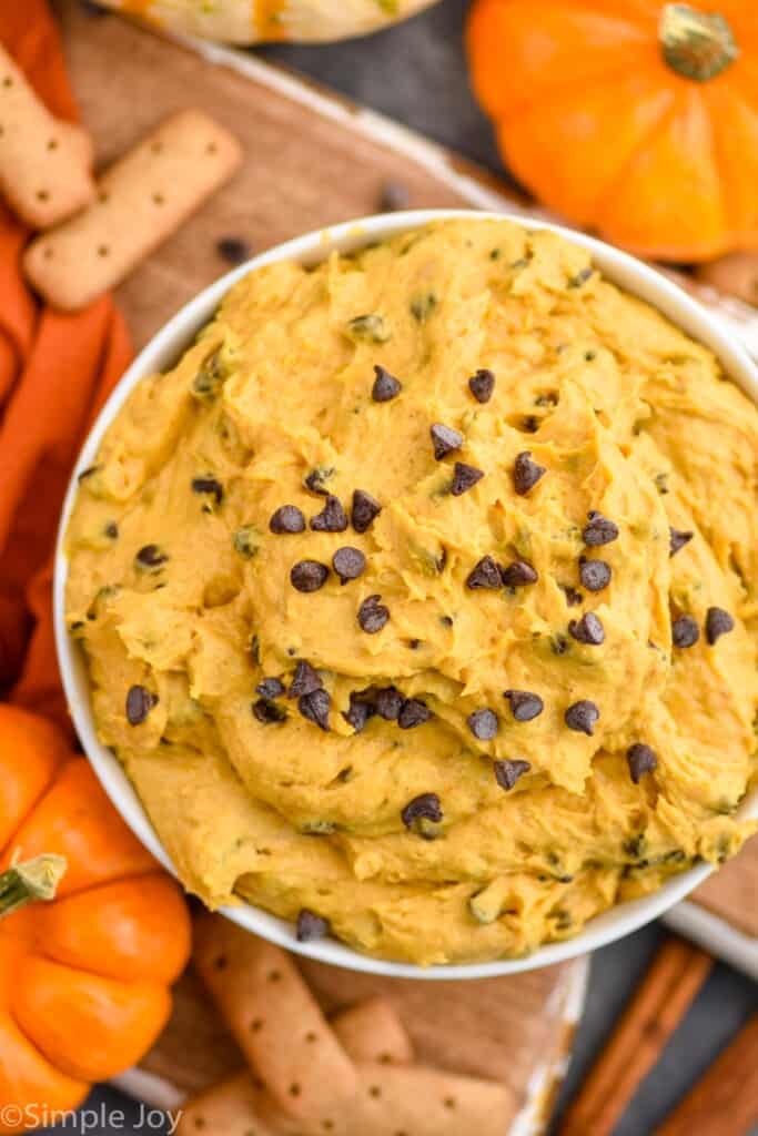 overhead picture of pumpkin dip in a white bowl with mini chocolate chips mixed in
