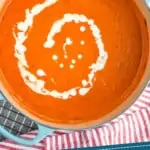 pinterest graphic of overhead of a tomato bisque recipe that is drizzled with cream in a large stock pot