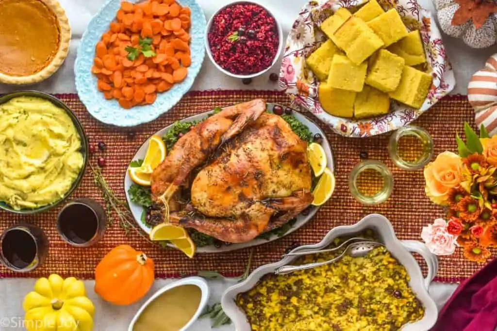 overhead view of a thanksgiving table, with a roast turkey and all the sides