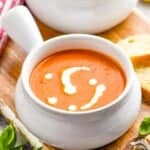 small soup bowl full of tomato bisque with cream drizzled on top