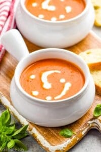 small soup bowl full of tomato bisque with cream drizzled on top
