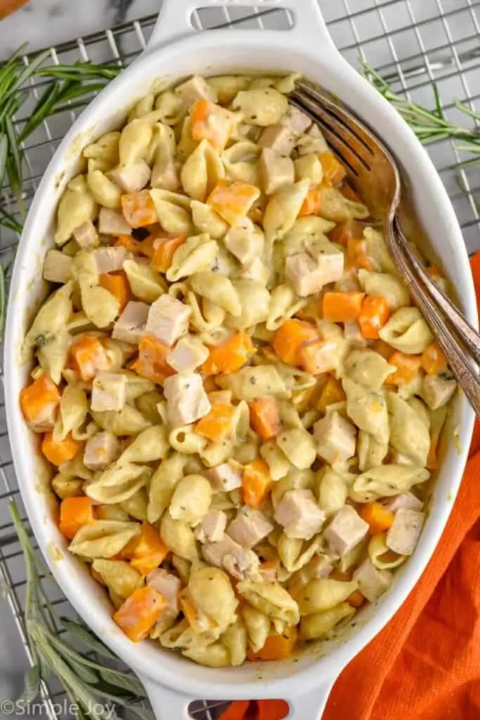 overhead of leftover turkey casserole in a baking dish with two forks