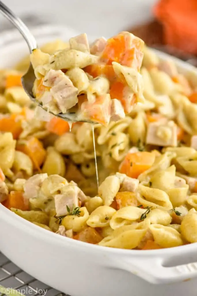 serving spoon dishing up turkey noodle casserole