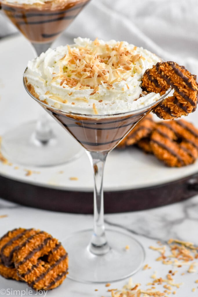 Overhead photo of Samoa Martini garnished with Samoa cookie. Extra Samoa cookies on counter for garnish.