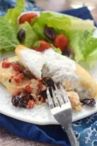 a fork digging into greek stuffed chicken