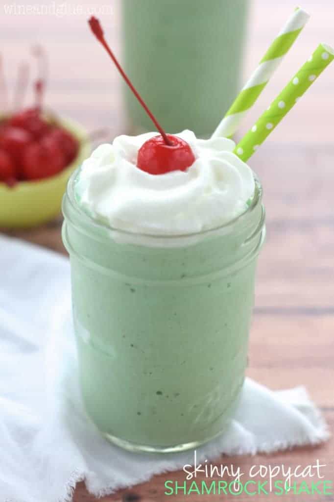 In a mason jar, the Skinny Shamrock Shake has a darker neon green color with whipped cream and a maraschino cherry on top. 
