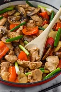 Serving spoon digging into a skillet of easy szechuan chicken