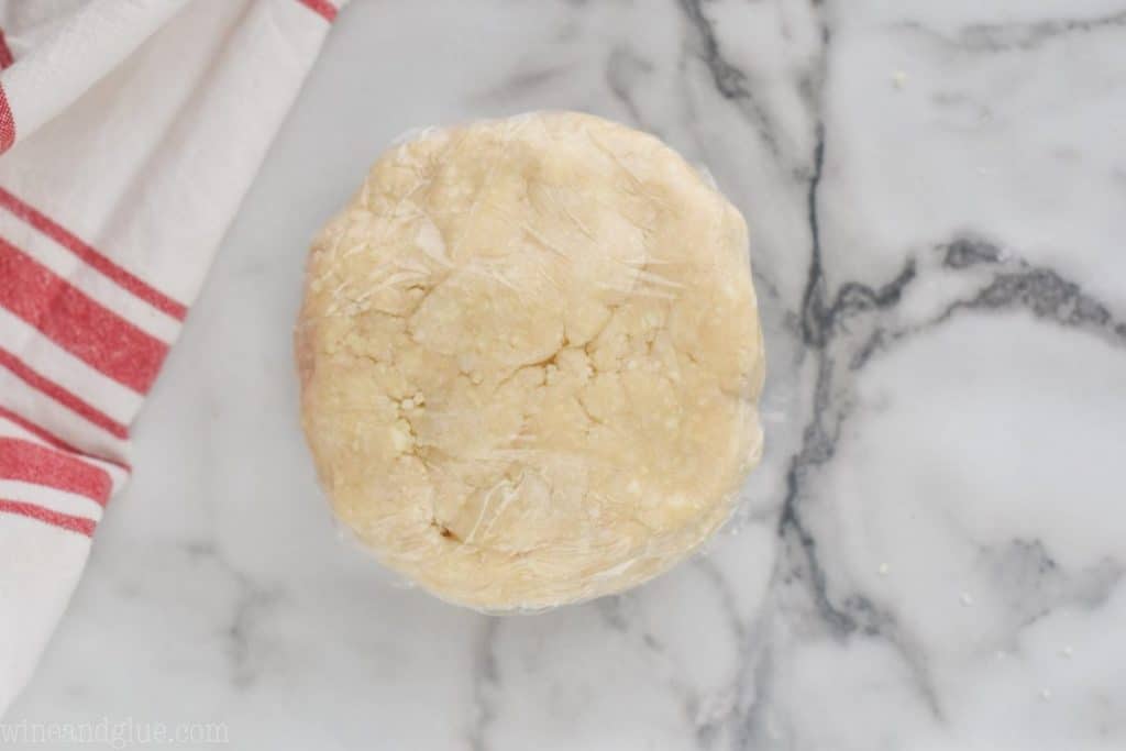 a disk of pie crust that has been wrapped tightly with plastic wrap to be put in the refrigerator - 24