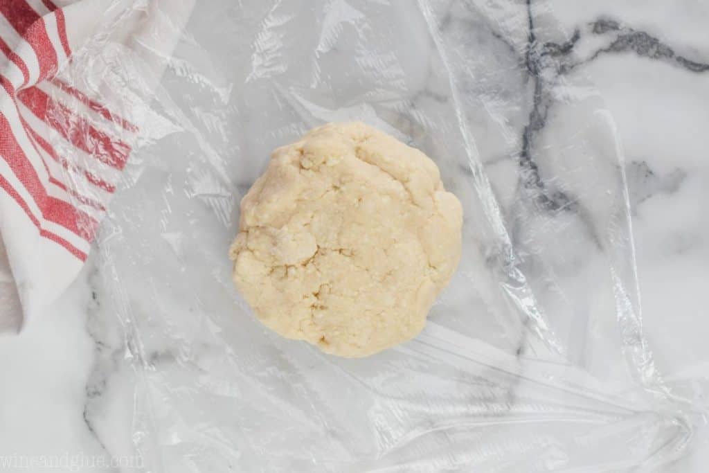 a disk of pie crust sitting on plastic wrap waiting to be wrapped - 23