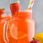 large glass of strawberry lemonade with a strawberry sliced and on the glass as a garnish - 12