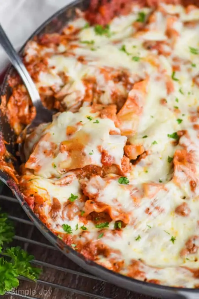 close up of a skillet with skillet lasagna and spoon dishing into it