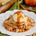 apple cobbler recipe on white plate with ice cream and caramel