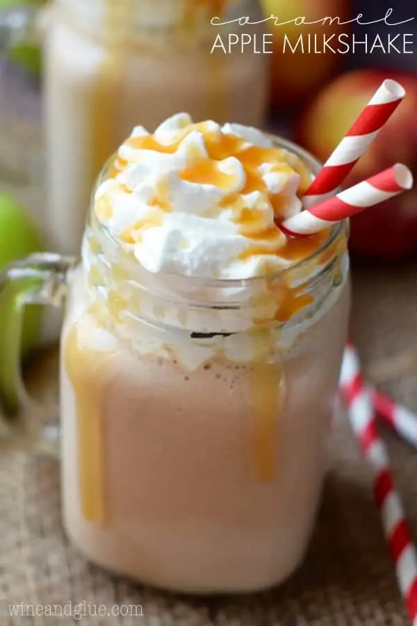 In a mason jar glass, the Caramel Apple Milkshake is topped with whipped cream and caramel dripping down the sides. 