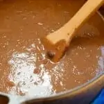 In a colorful bowl, the Creamy Chipotle Black Bean Soup has a dollop of sour cream in the middle topped with cilantro.