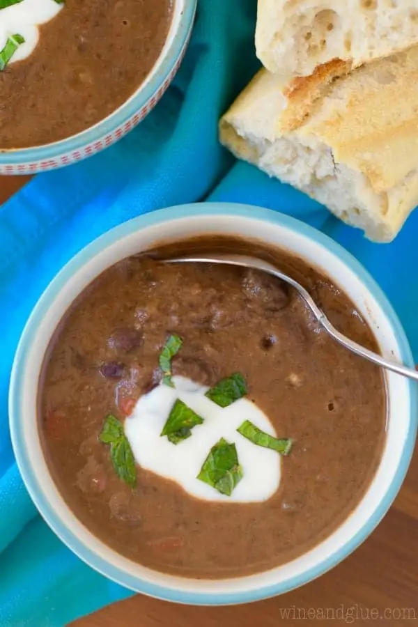 An overhead photo of the Creamy Vegan Black Bean Soup with a spoon digging into it. 