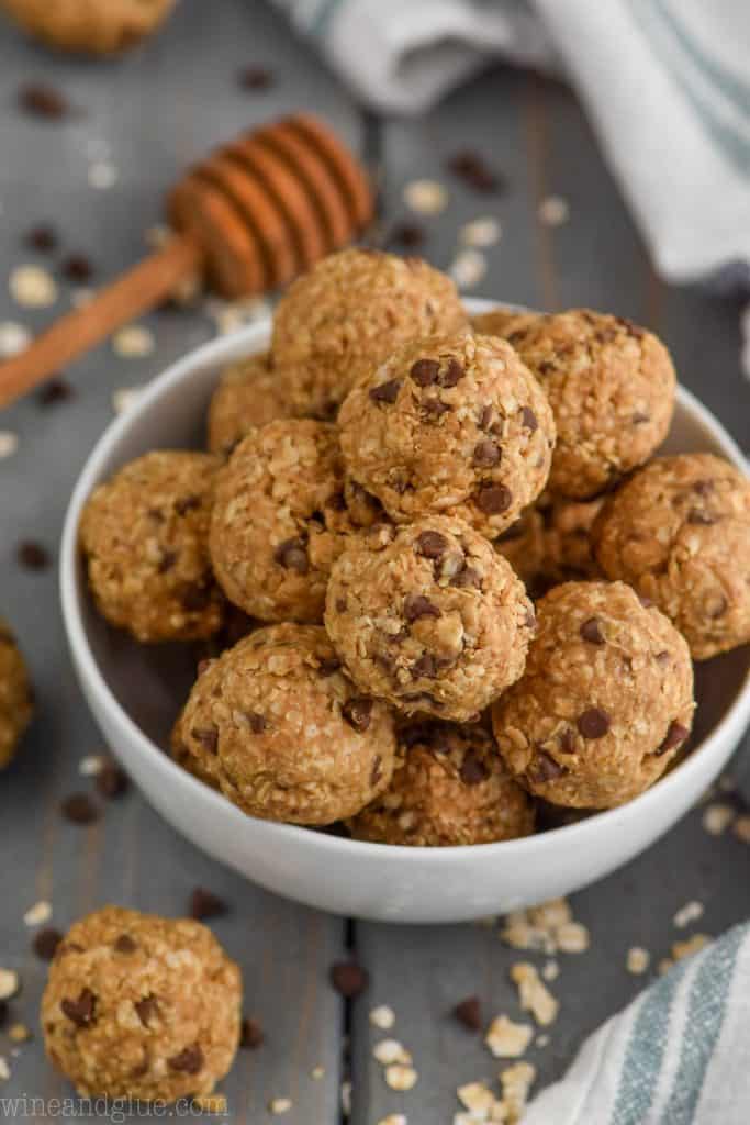 In a white bowl, the Five Ingredient No Bake Energy Bites are shaped into little balls and piled on top of each other. 