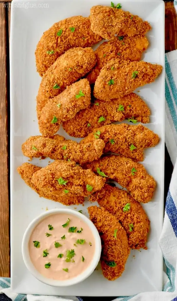 An overhead photo of the Baked Chicken Tenders that have a crispy golden brown outside with a yogurt based sauce.