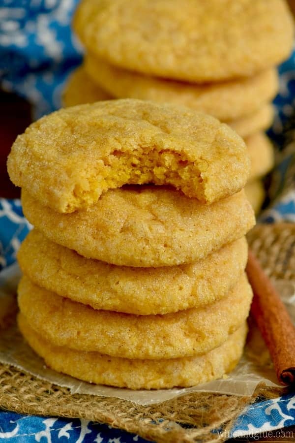 The Pumpkin Sugar Cookies are staked on top of each other having an orange gold hue. 