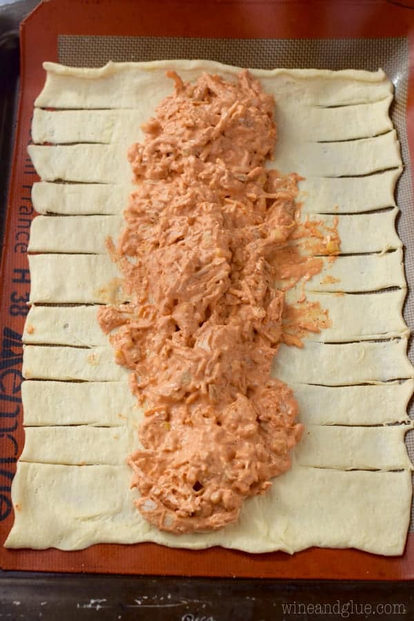 Chicken Enchilada filling on Crescent Bread dough with slits cut into the sides.