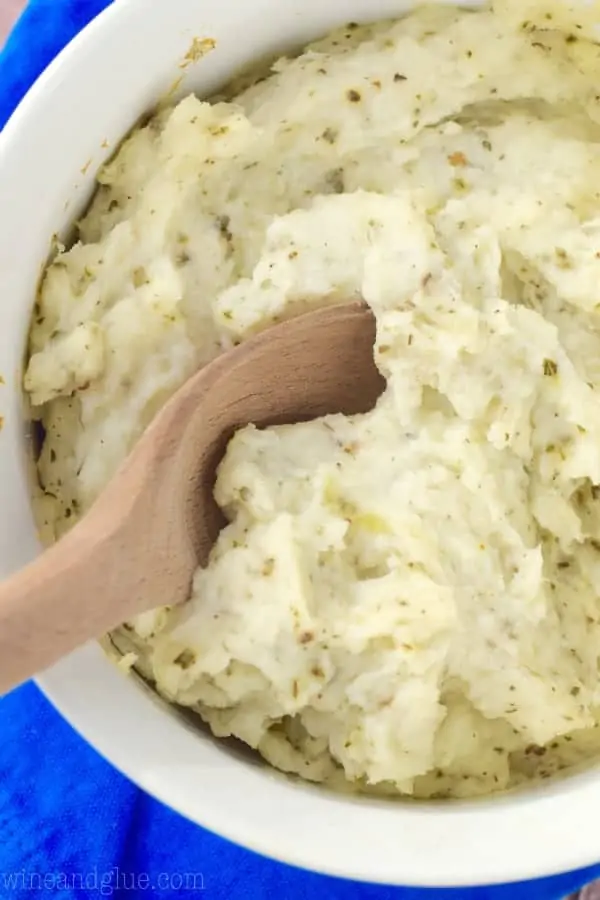 An overhead photo of the the Italian Mashed Potatoes showing a spoon digging into the fluffy creamy mashed potatoes. 