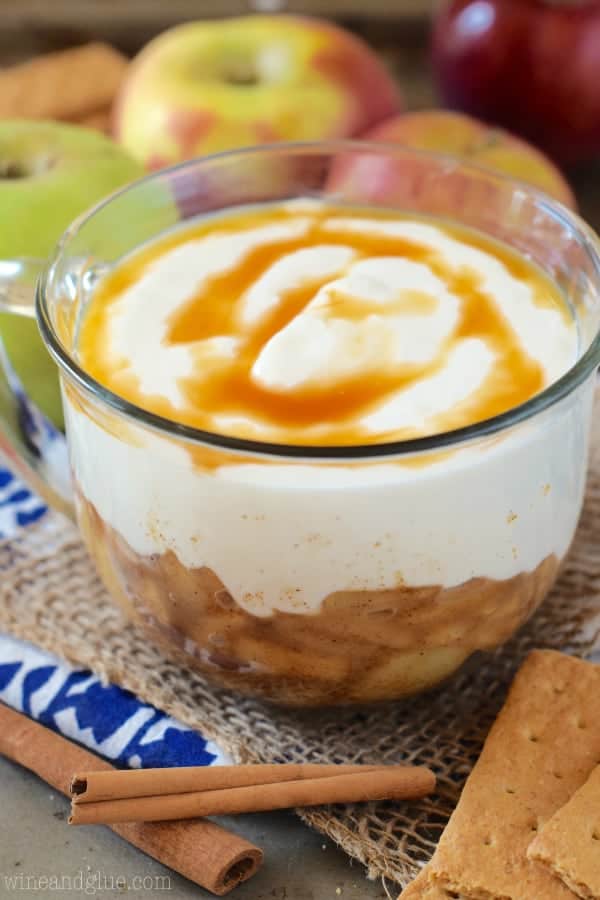 In a glass bowl, the Lightened Up Apple Cider Dip has two distinct layers: sauteed apples in the bottom and topped with yoplait yogurt with caramel. 