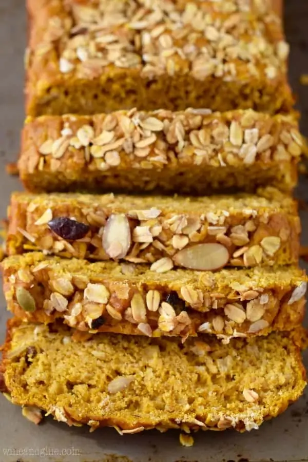 The Muesli Pumpkin Bread are cut into slices and the top of the bread is sprinkled with different types of seeds and nuts. 