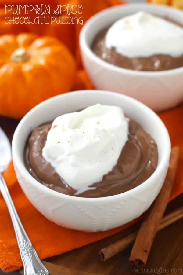 In a small white bowl, the Pumpkin Spice Chocolate Pudding has a dollop of whipped cream. 