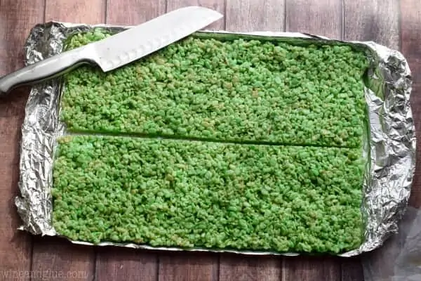 An overhead photo of a the green Rice Krispies on a baking sheet cut horizontally in the middle. 